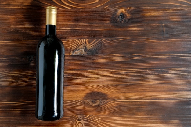 A dark bottle of wine on a wooden table