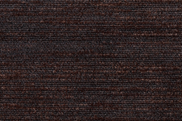 Dark brown background from soft textile material. Fabric with natural texture.