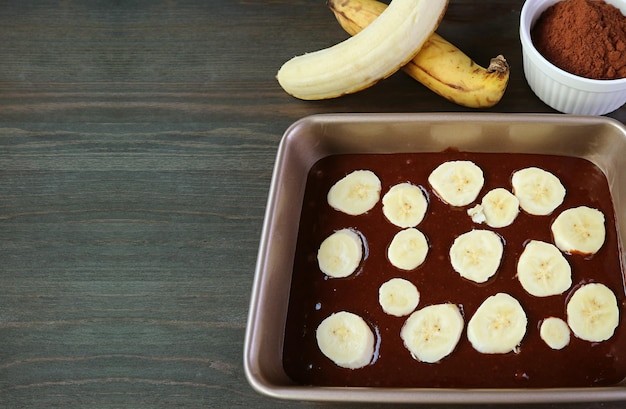 Dark Chocolate Banana Cake Batter in Cake Pan before Baking on Wooden Table