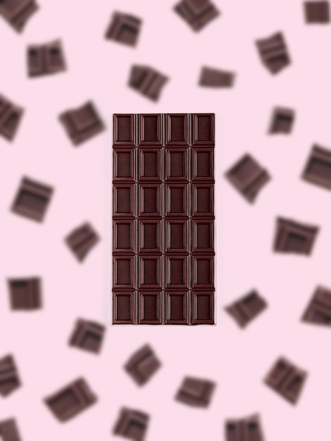 Dark chocolate on the pink background with flying chocolate bars