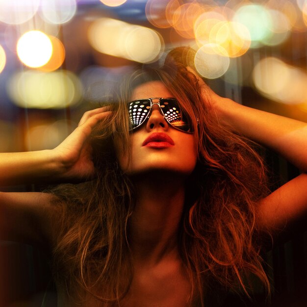 dark color toned picture of fashionable woman in nightclub