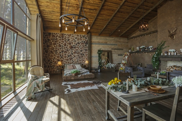 Dark cozy interior of big country wooden house, wooden furniture and animal furs. huge panoramic window and very high ceiling.