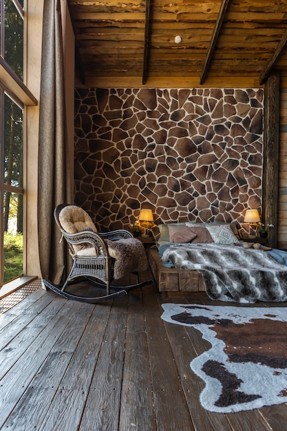 Dark cozy interior of big country wooden house, wooden furniture and animal furs. huge panoramic window and very high ceiling.