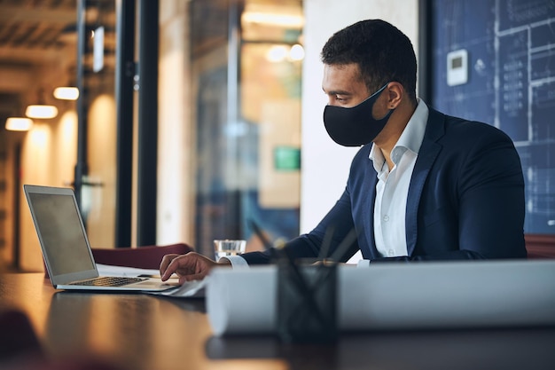 Dark-haired engineer using the computer in the workplace