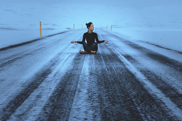 Photo dark haired model is posing sitting on a road