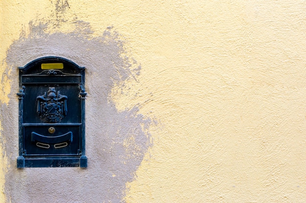 Dark mailbox on a partially painted wall