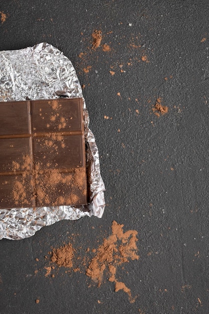 Dark natural chocolate bars on dark background with copy space