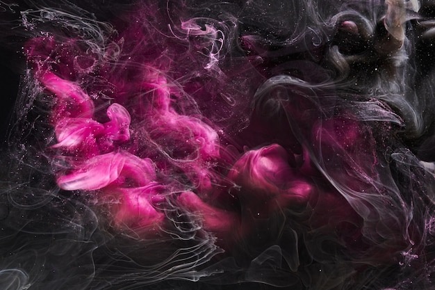 Dark Pink and black abstract ocean background Splashes drops and waves of paint under water clouds of smoke in motion