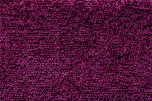 Dark purple fluffy background of soft, fleecy cloth. Texture of textile closeup