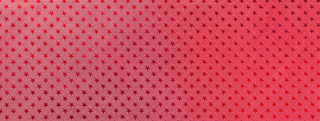 Dark red christmas background from metal foil paper with a pattern of sparkling stars macro Wine backdrop