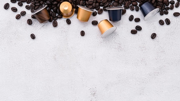 Dark roasted coffee beans setup on white concrete background with copy space