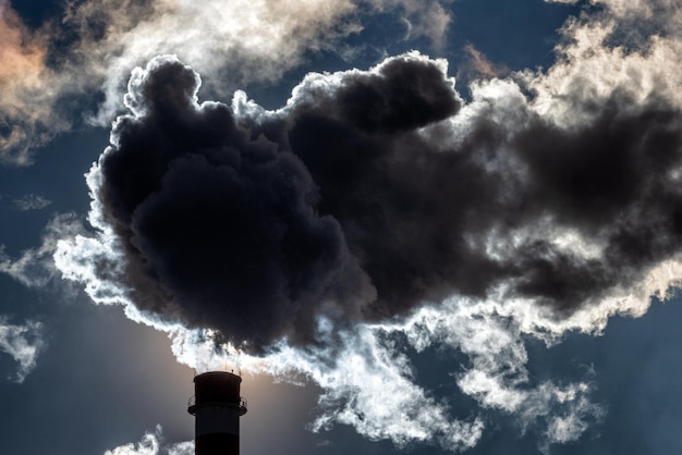 Photo dark smoke from smokestack against the sky