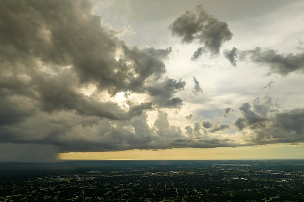 Dark stormy clouds forming on gloomy sky during heavy rainfall season over suburban town area