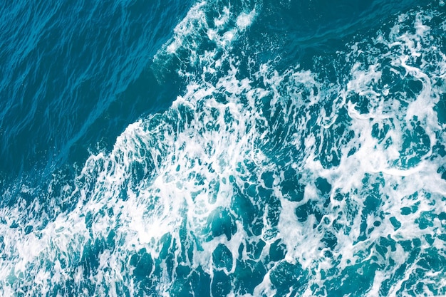 Dark stormy sea with foam sea water surface top view