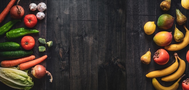 Dark wooden background with fruits vegetables on the sides Banner for greengrocers and supermarkets