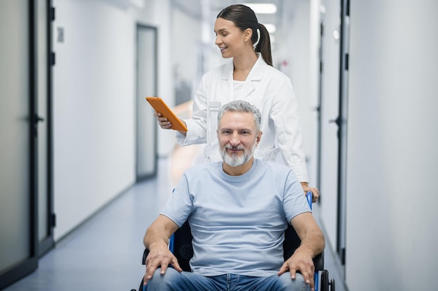 Darkhaired nurse carrying the wheelchair with a patient