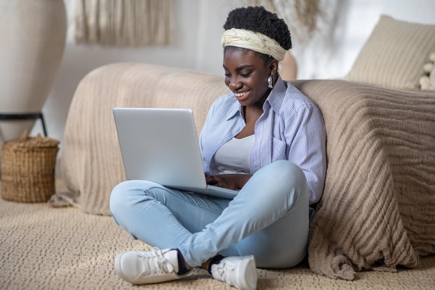 Darkskinned smiling woman witha laptop