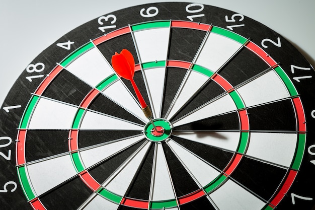 Dart arrow hitting in the target center of dartboard. concept of the success