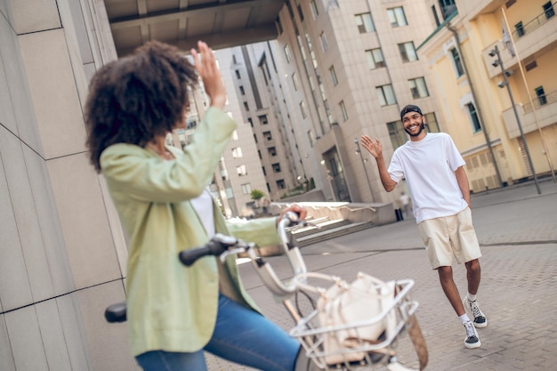 Date. Curly-haired girl with a bike meeting her boyfriend