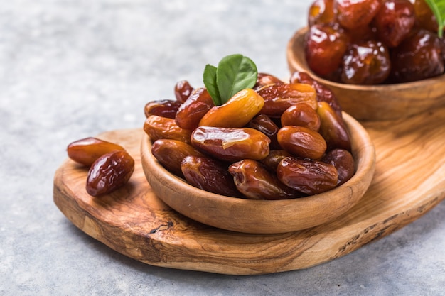 Dates or dattes palm fruit in wooden bowl is snack healthy.