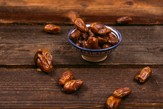 Dates fruit in bowl on wooden table