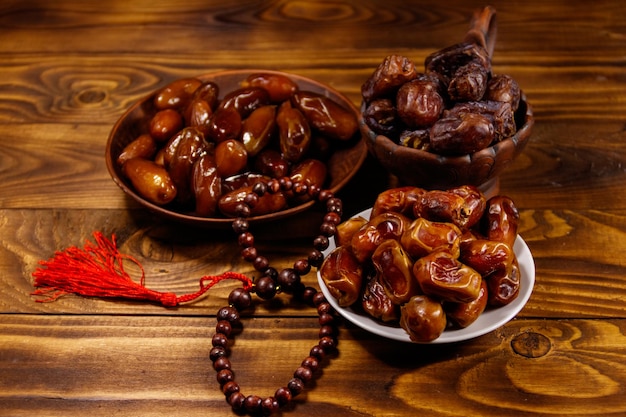 Dates fruit and rosary on wooden table