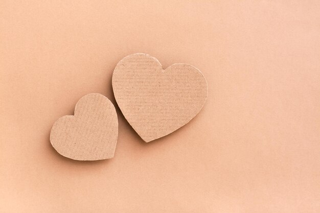 Photo dating concept two cardboard hearts together on a beige background top view valentines day