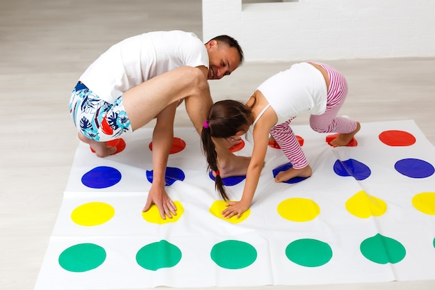 Photo daughter and father play twister at home