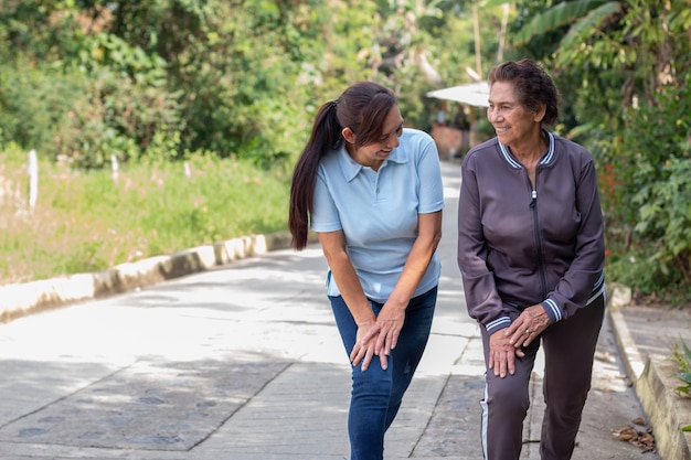 Daughter helping her elderly mother to exercise Concept of healthy living and active aging