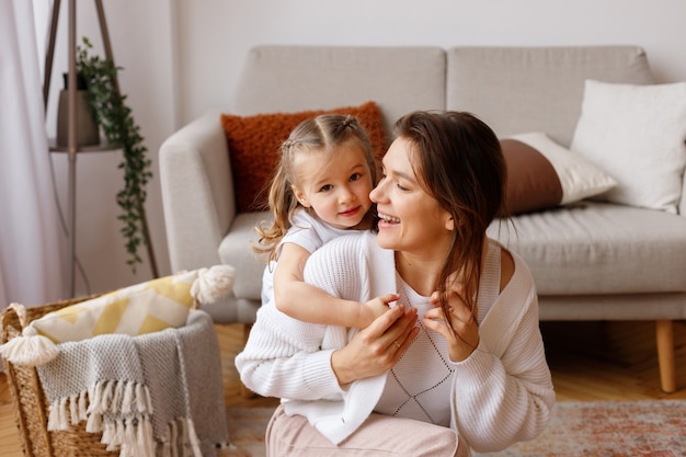 Daughter hugs her mother in the living room on holiday