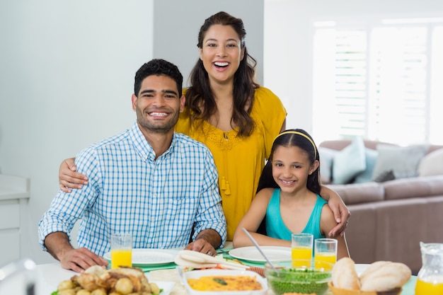 Daughter and parents having meal on table at home