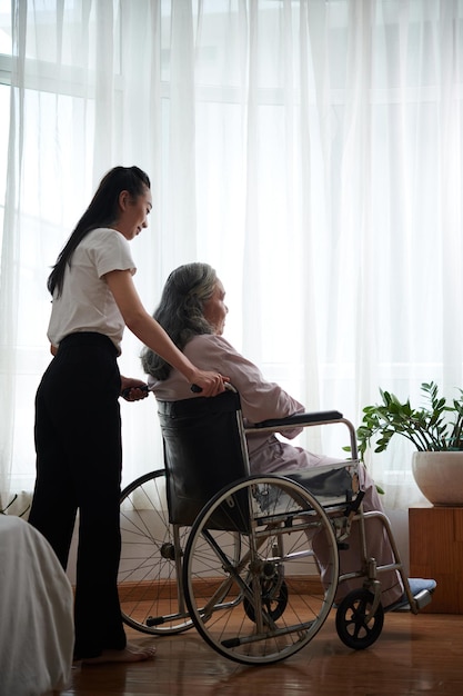 Daughter Pushing Wheelchair of Senior Mother