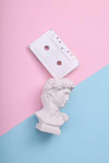 David bust with audio cassette on pink blue background Creative layout Minimal music still life Flat lay Top view