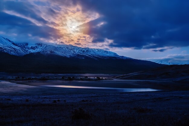 Dawn dusk over Lake Dzhangyskol in the tract Yeshtykol and the North Chuysky ridge in the moonlight. Russia, Altai Republic