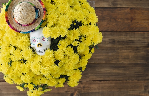 Day of the Dead. Skull and yellow flowers on wooden background. Copy space.