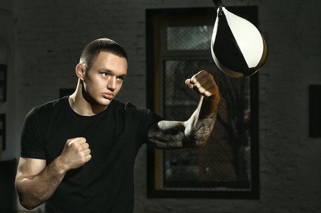 Not a day without training. Strong and fit fighter working out with a speed bag