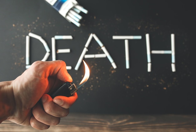 Death sign from cigarettes Dangerous habit Harmful for health Man holds lighter in hands