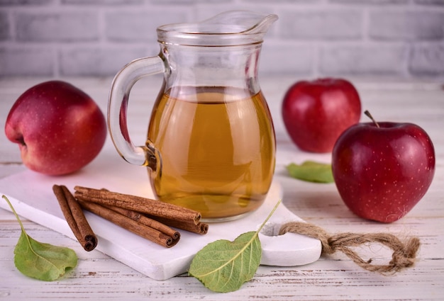 Decanter with fresh apple juice and red apples.