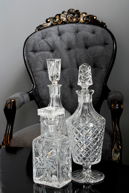 decanters still life of glass decanters on a wooden table and classic style gray armchair