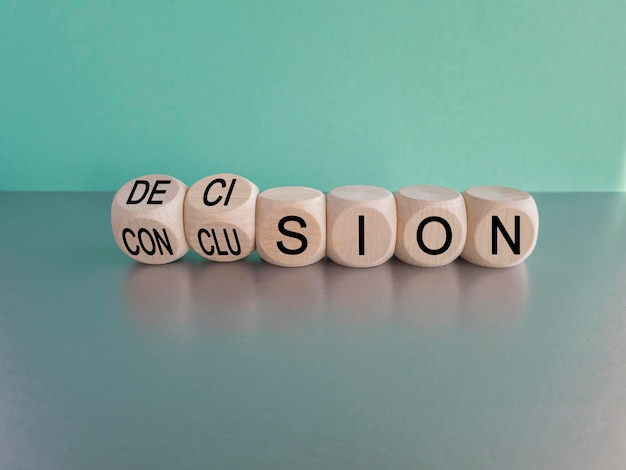 Decision or conclusion symbol Turned wooden cubes and changes the word 'conclusion' to 'decision'