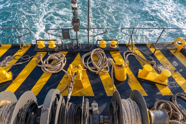 The deck of the ferry boat along with the a thick mooring rope and blue sea water wave Thailand Close up