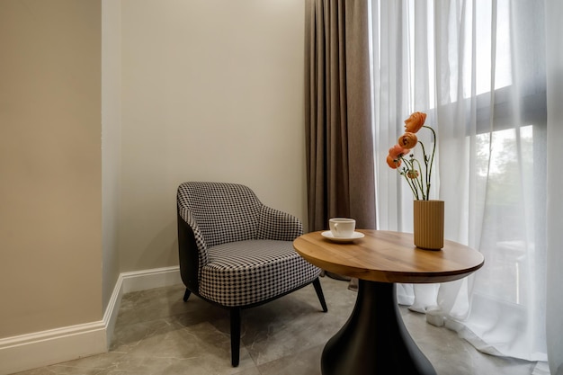 Decor elements of the guest room and rest room with a tea table an armchair and a bouquet of flowers and a cup of coffee