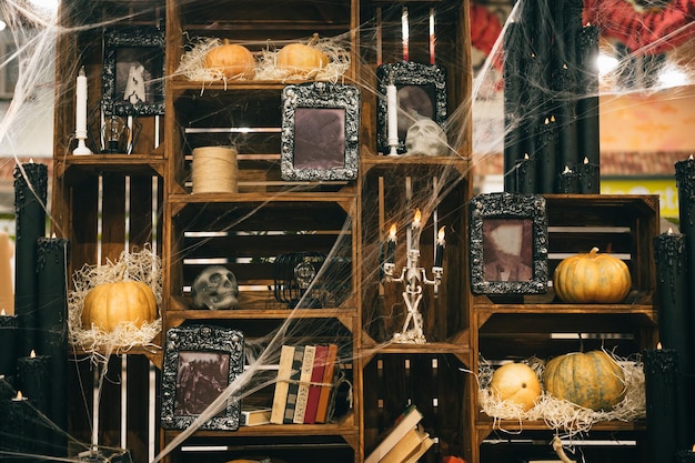 decor on the shelves of the cabinet for Halloween in the web and with skulls and pumpkins