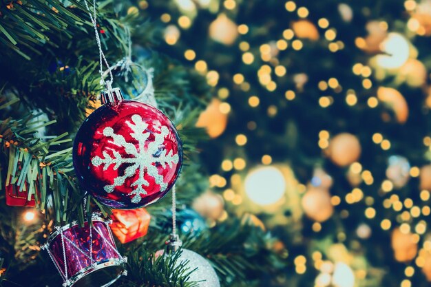 Decorated Christmas tree with colorful bauble on sparkling bokeh light blurred background