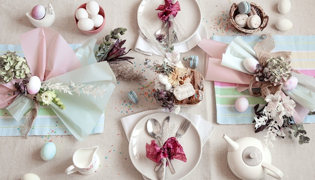 Decorated festive table with Easter dessert, tea and eggs flat lay. Happy Easter concept.