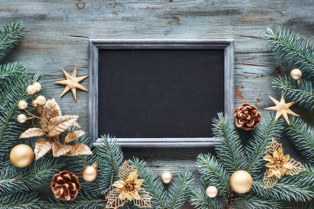 Decorated fir twigs around chalk board on rustic wood, to view, text space