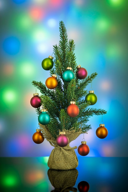 Decorated green Christmas tree on blurred colorful scene