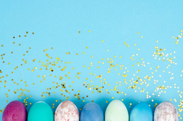 Decorated handmade Easter eggs for the holiday season on blue background. Creative minimal abstract  concept. Studio Photo