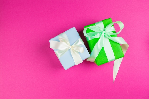 decorated present with a bow on pink background