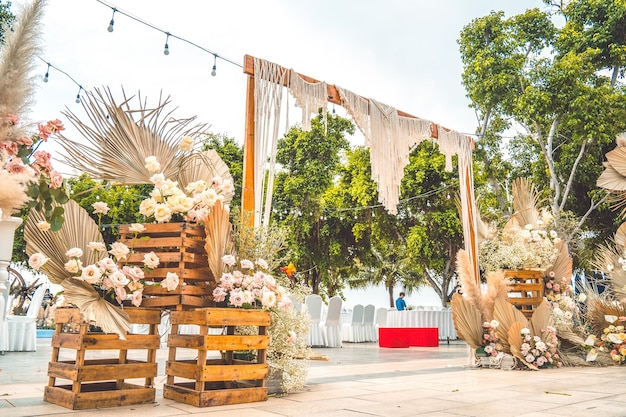 Decorating the arch with flowers and fabric for a wedding ceremony in nature Wedding Ceremony with flowers outside in the garden with hanging lights